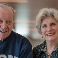 Gentleman with GVSU sweatshirt and woman with blazer smiling for photo